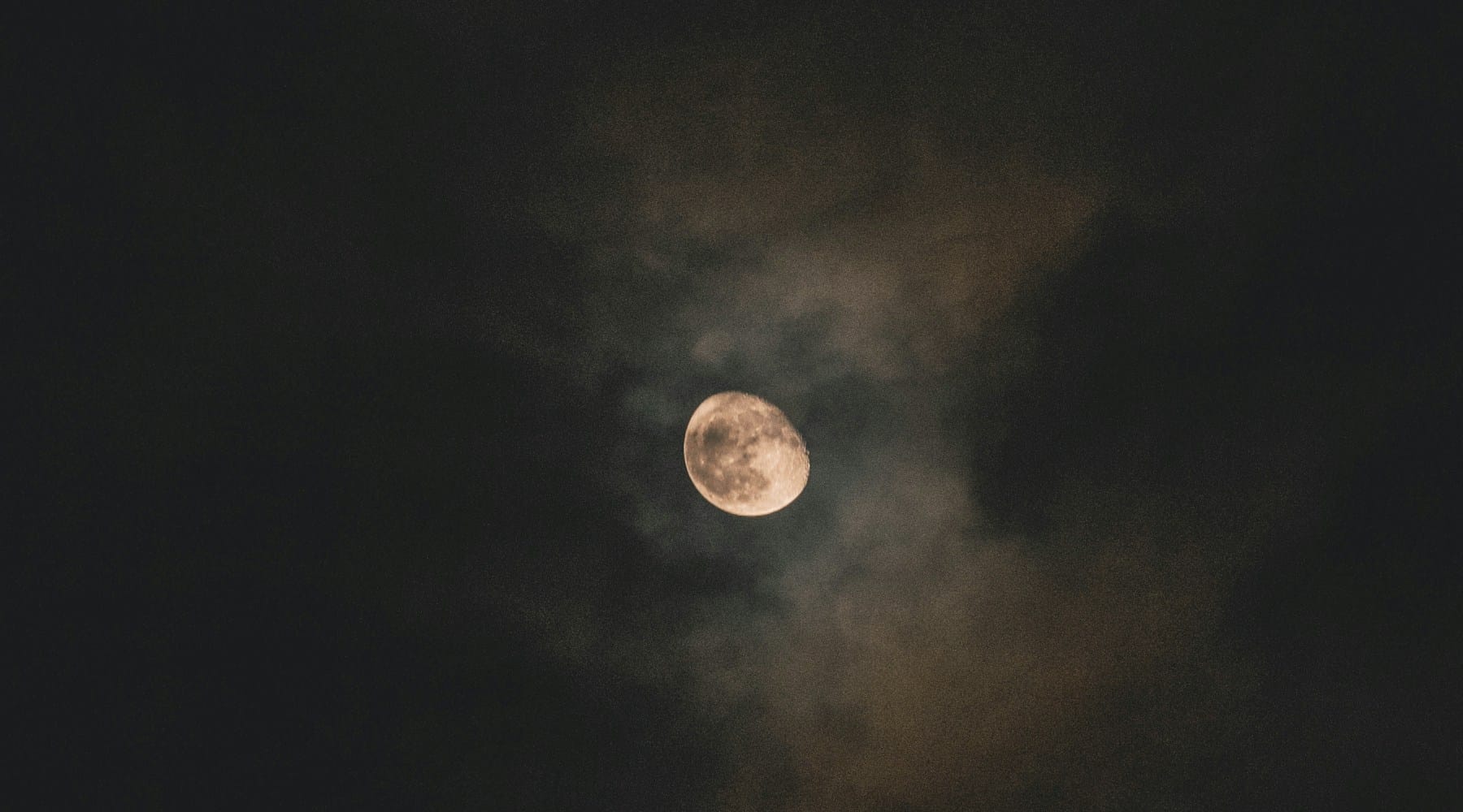 Lua cheia por entre nuvens escuras, num céu de noite